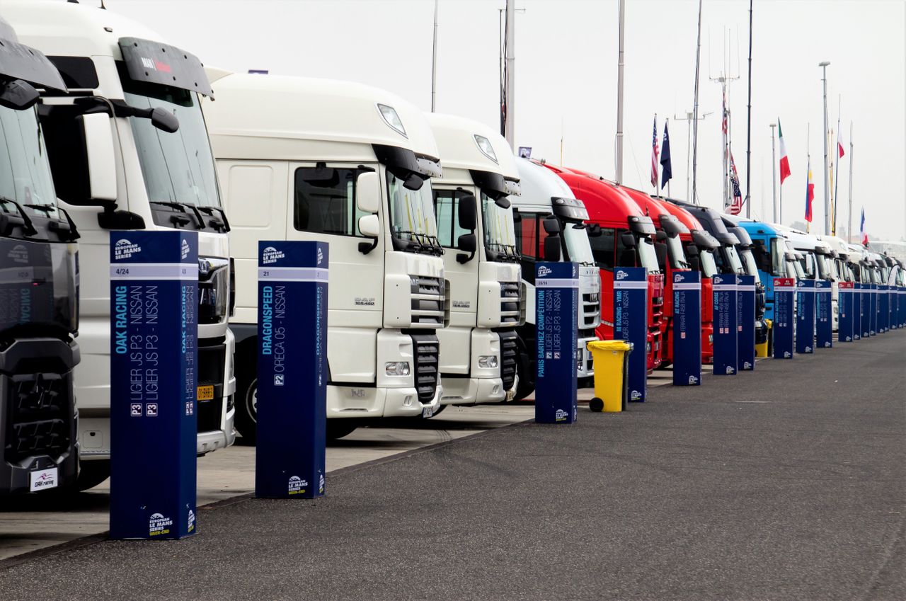 Line of racing trucks with bollards at event in Estoril, Portugal.